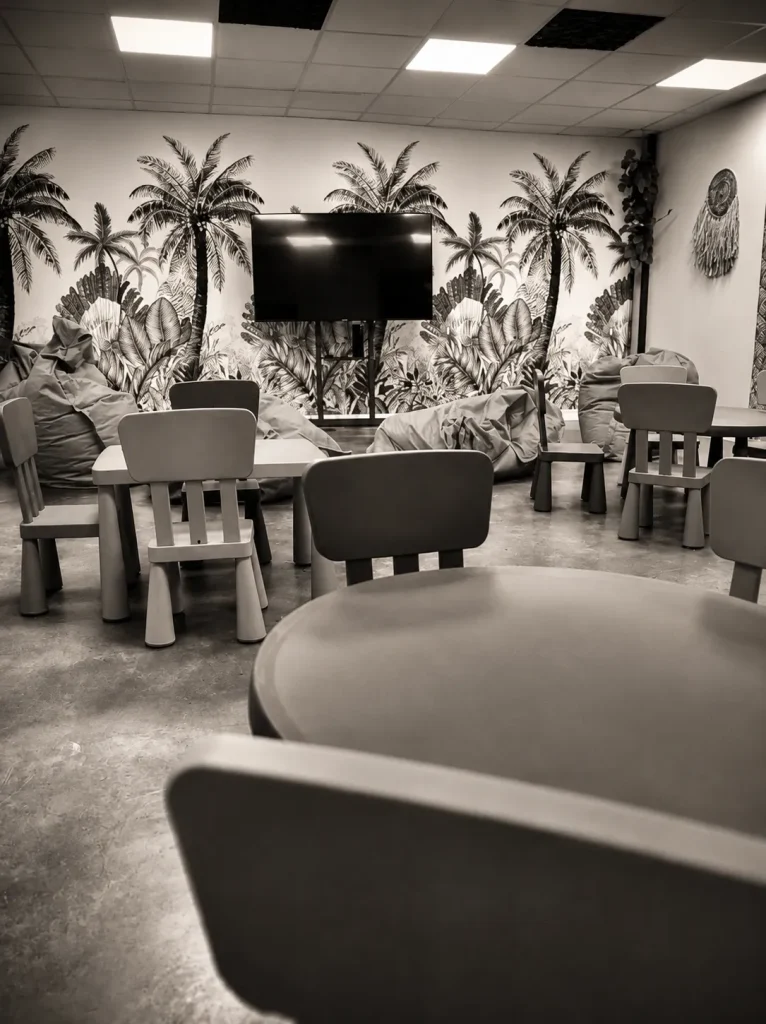 La Jungle Room du Recept', espace enfants avec petites tables, poufs et écran